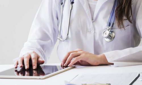 Descarga gratis Primer Plano De Una Doctora Usando Tableta Digital E Informe Médico En El Escritorio